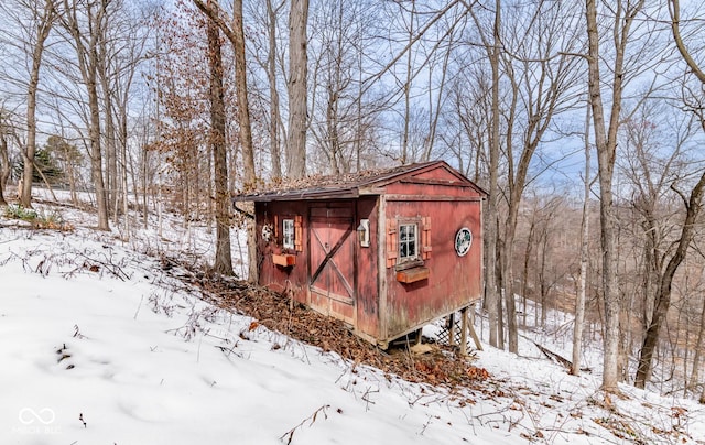 snow covered structure featuring a garage