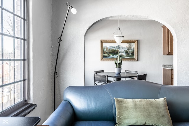 dining area with arched walkways and a textured wall