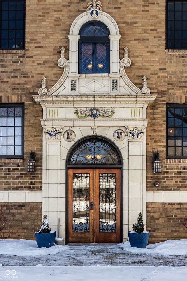 snow covered property entrance featuring french doors