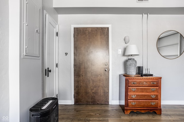 interior space with dark wood-style floors, electric panel, and baseboards