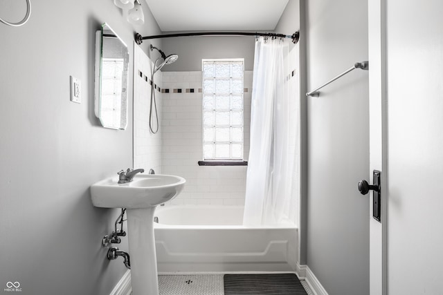 full bath featuring shower / bath combo and baseboards