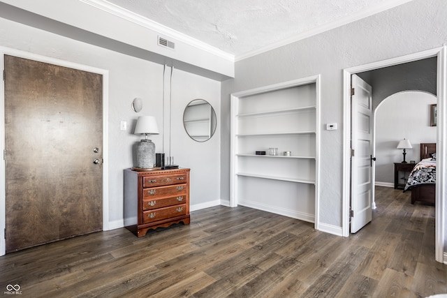 bedroom with baseboards, visible vents, ornamental molding, dark wood-style flooring, and a textured ceiling