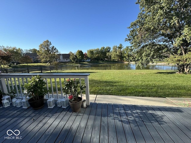 wooden terrace featuring a water view and a lawn