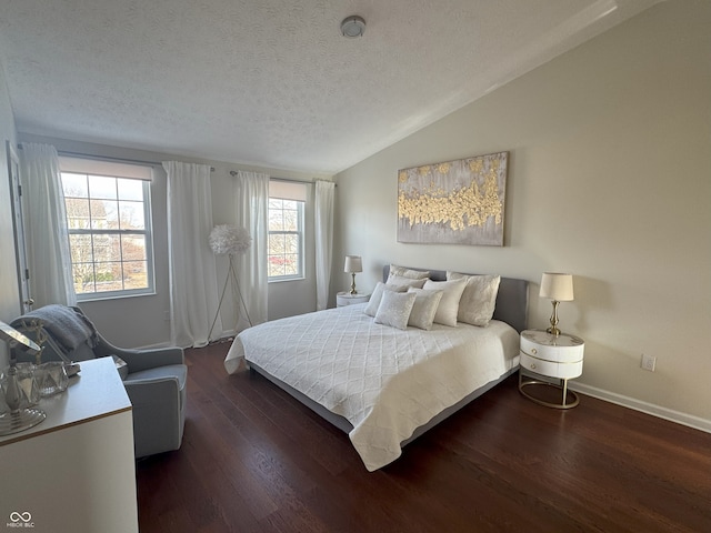 bedroom with lofted ceiling, dark hardwood / wood-style floors, and a textured ceiling