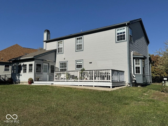 rear view of property with a wooden deck and a yard