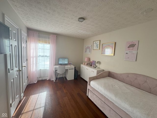 bedroom featuring dark wood-type flooring and a textured ceiling