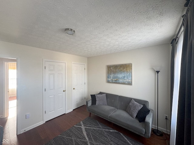 living room with dark wood-type flooring and a textured ceiling