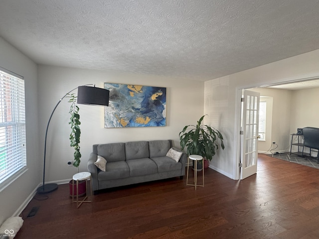 living room featuring dark hardwood / wood-style flooring and a textured ceiling