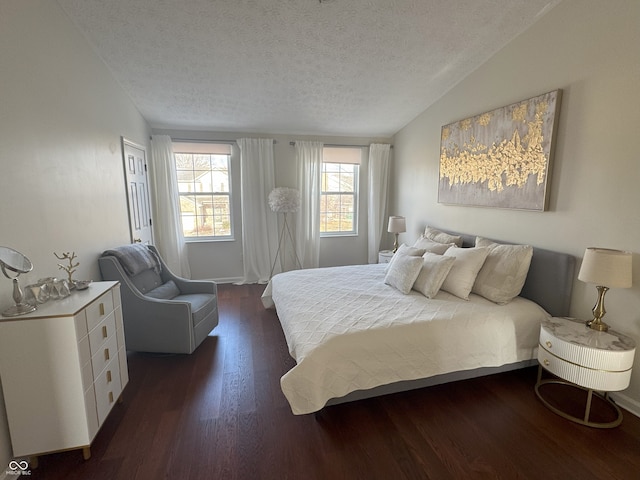 bedroom featuring lofted ceiling, dark hardwood / wood-style flooring, and a textured ceiling