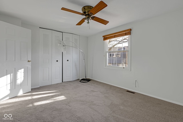 unfurnished bedroom with ceiling fan, carpet flooring, and a closet