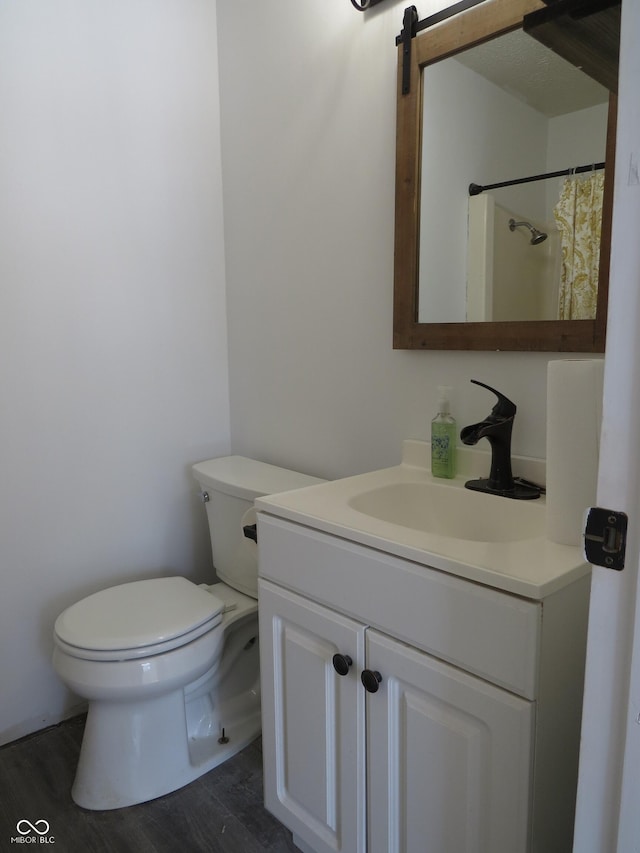 full bath featuring toilet, curtained shower, wood finished floors, and vanity