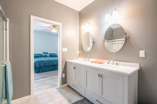 full bathroom featuring a ceiling fan, a sink, baseboards, and double vanity