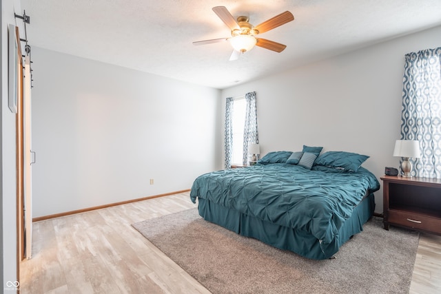 bedroom featuring light wood-type flooring, ceiling fan, and baseboards