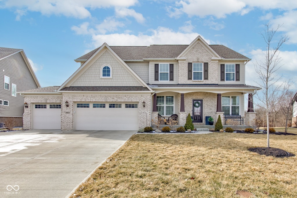 craftsman-style home featuring a porch, a garage, and a front lawn