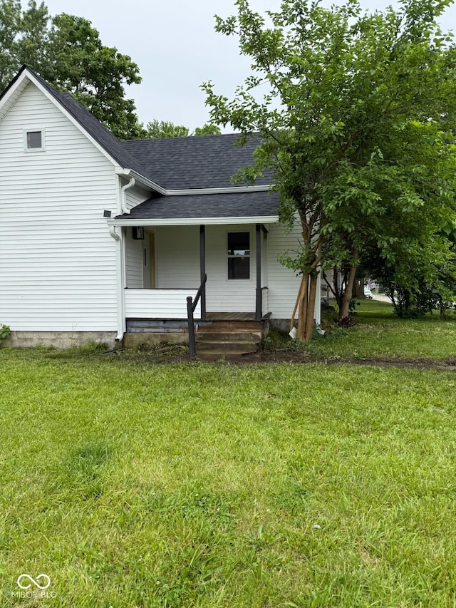 2312 Fletcher St, Anderson, IN 46016 - view of front of home with covered porch, a shingled roof, and a front yard
