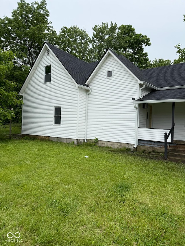 2312 Fletcher St, Anderson, IN 46016 - view of side of property with a yard, a shingled roof, and covered porch