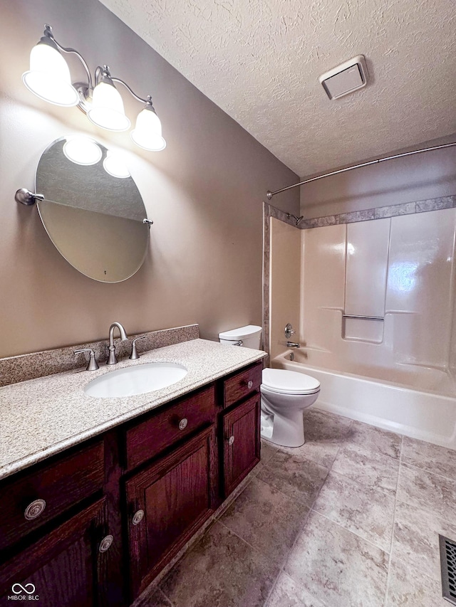 bathroom featuring tile patterned floors, toilet, a textured ceiling, shower / bathing tub combination, and vanity