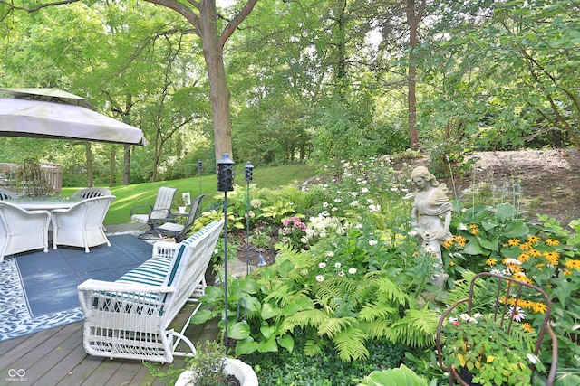 view of yard featuring a deck, a gazebo, and outdoor dining area