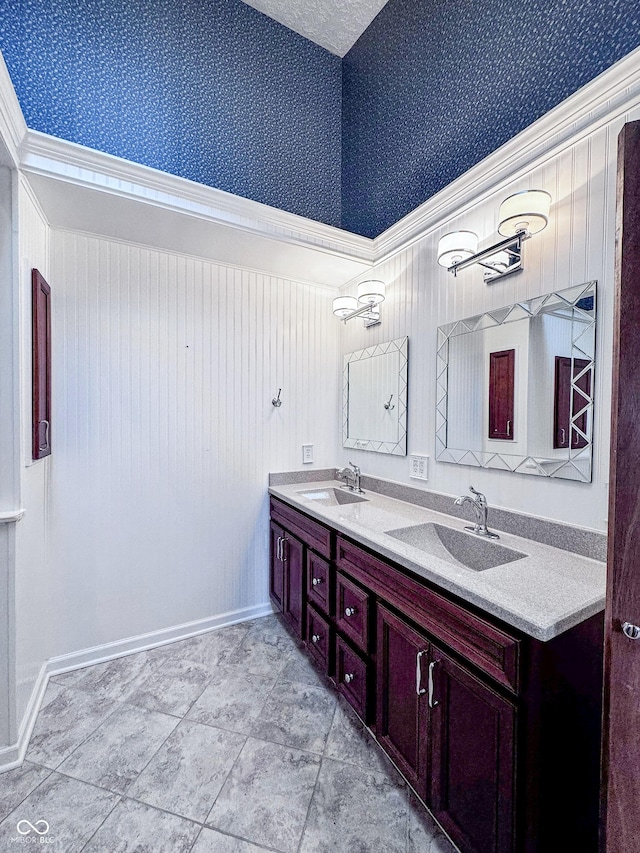 bathroom featuring a sink, double vanity, and wallpapered walls