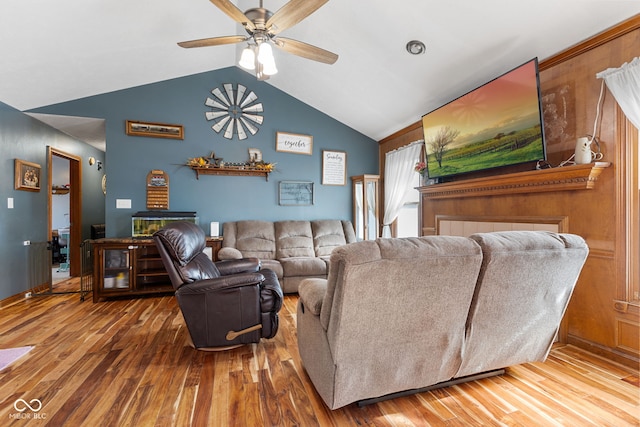 living area with lofted ceiling, a ceiling fan, and wood finished floors