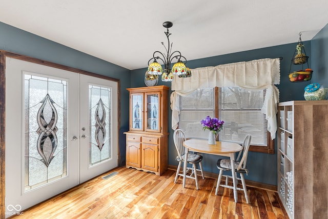 dining room featuring baseboards, french doors, visible vents, and light wood-style floors
