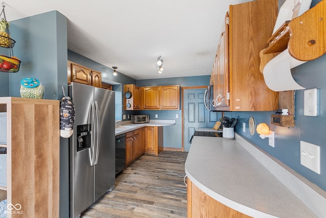 kitchen featuring black dishwasher, light countertops, brown cabinetry, and stainless steel fridge with ice dispenser