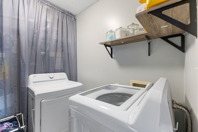 laundry area with laundry area, a textured ceiling, and washer and dryer