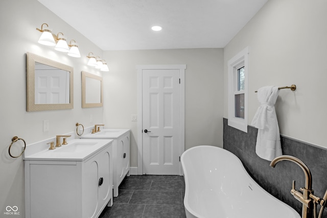 bathroom with tile patterned floors, vanity, and a tub