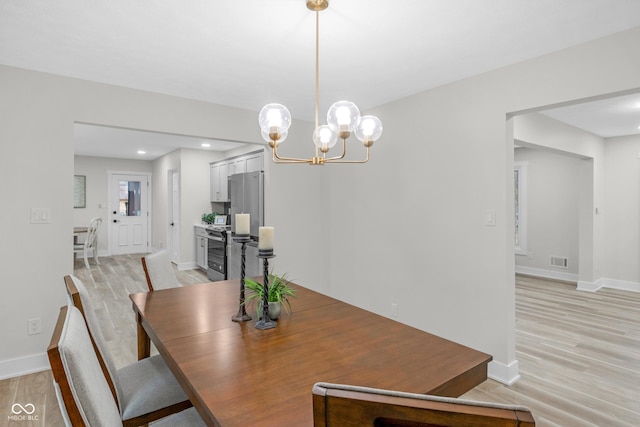 dining space with an inviting chandelier and light wood-type flooring