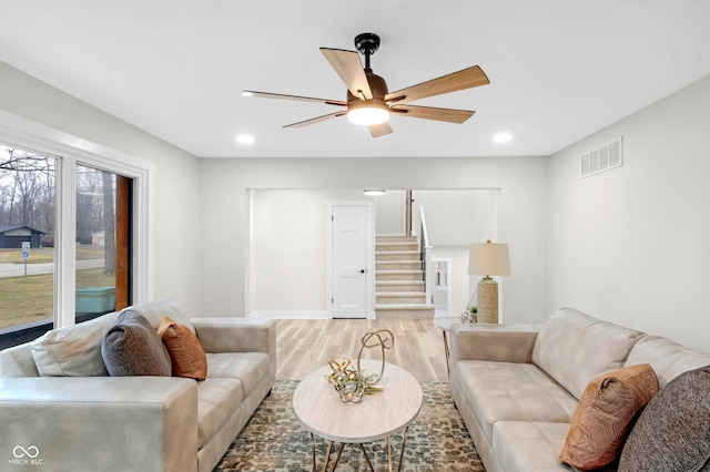 living room featuring light hardwood / wood-style floors and ceiling fan