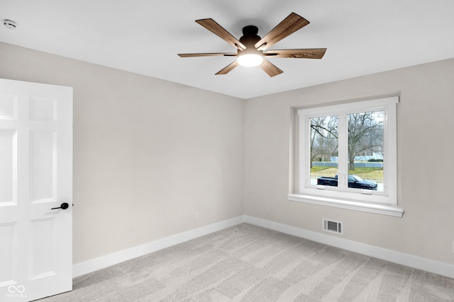 carpeted spare room featuring ceiling fan