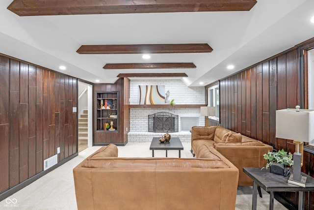 living room featuring a brick fireplace, light colored carpet, and wooden walls