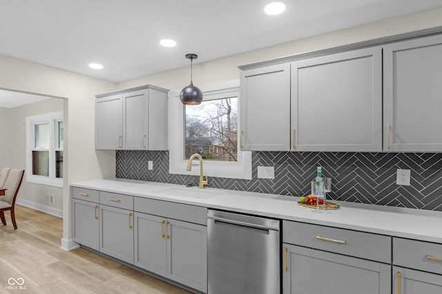 kitchen with decorative light fixtures, dishwasher, sink, and gray cabinetry