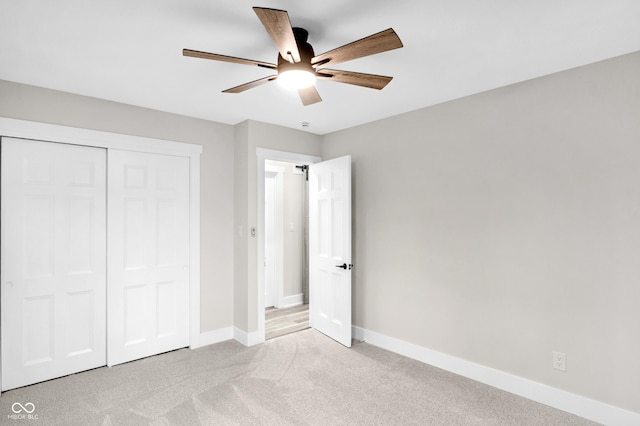 unfurnished bedroom featuring light colored carpet, ceiling fan, and a closet