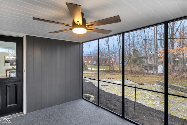 unfurnished sunroom with ceiling fan