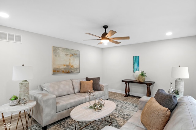 living room with light hardwood / wood-style flooring and ceiling fan