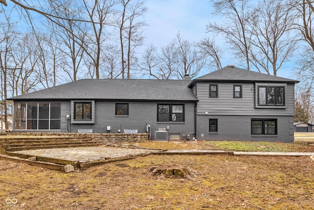 rear view of property with central AC unit and a sunroom