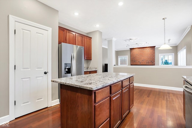 kitchen with appliances with stainless steel finishes, a kitchen island, decorative light fixtures, dark hardwood / wood-style flooring, and ornamental molding