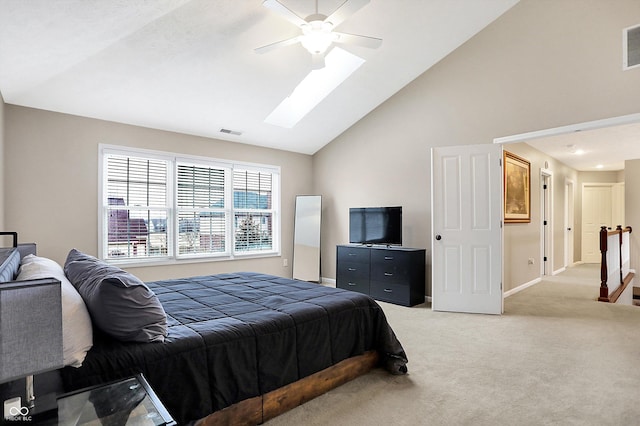 carpeted bedroom with high vaulted ceiling, ceiling fan, and a skylight