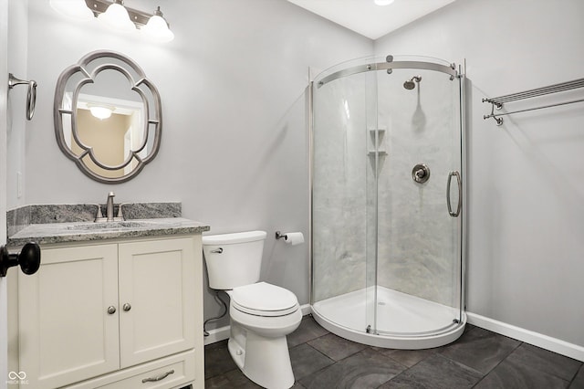 bathroom featuring tile patterned floors, vanity, toilet, and a shower with door