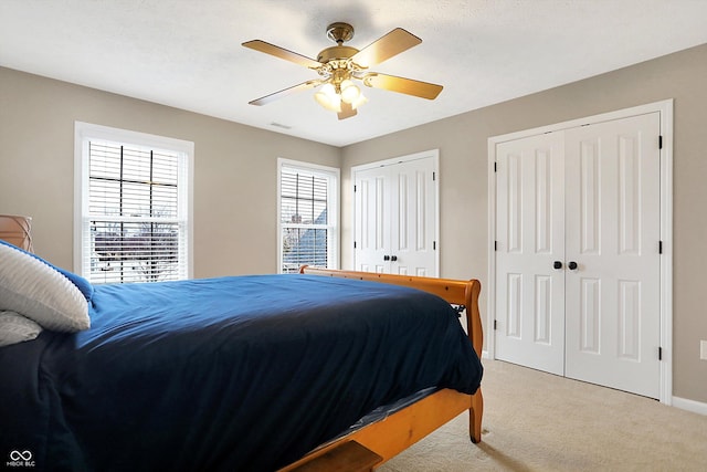 bedroom featuring carpet, two closets, and ceiling fan