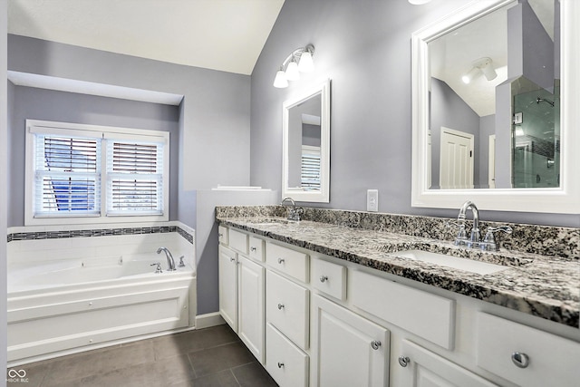 bathroom with tile patterned flooring, vanity, a bathtub, and lofted ceiling