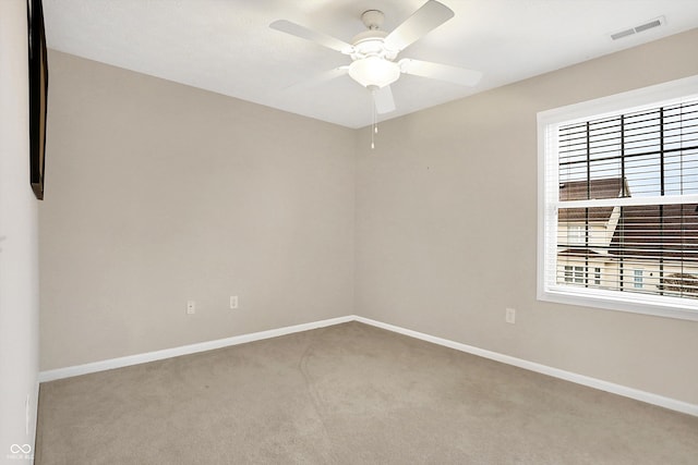 carpeted spare room featuring ceiling fan