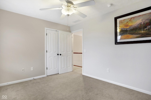 unfurnished bedroom with light carpet, ceiling fan, and a closet