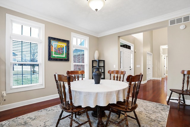 dining room with ornamental molding, dark wood-type flooring, and a wealth of natural light