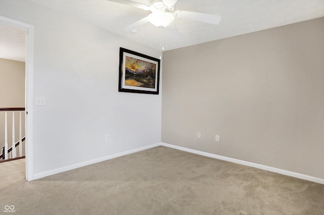 empty room featuring ceiling fan and carpet