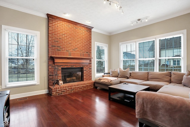 living room featuring a brick fireplace, plenty of natural light, ornamental molding, and dark hardwood / wood-style floors