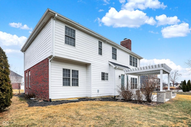 rear view of property with a pergola and a lawn