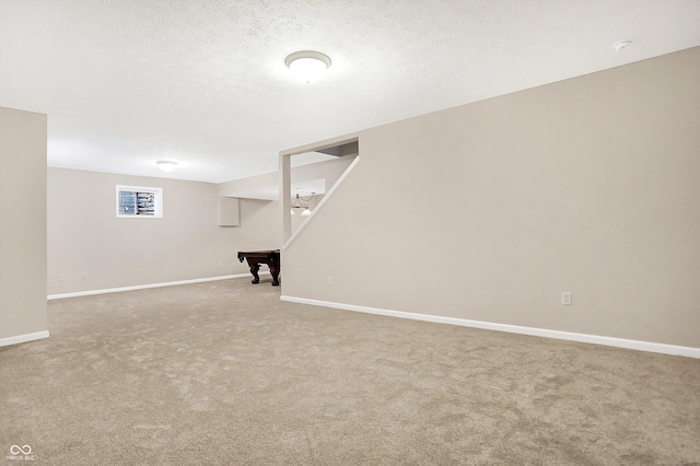 basement with carpet, a textured ceiling, and billiards