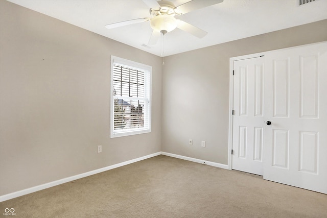 unfurnished bedroom with ceiling fan, a closet, and light carpet